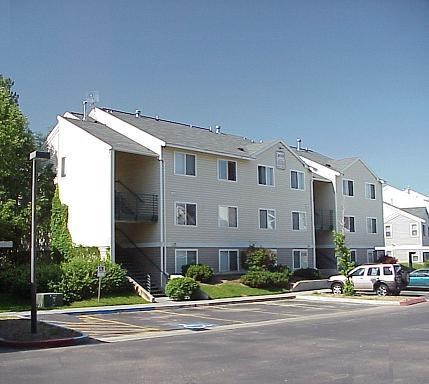 an apartment building with cars parked in front of it