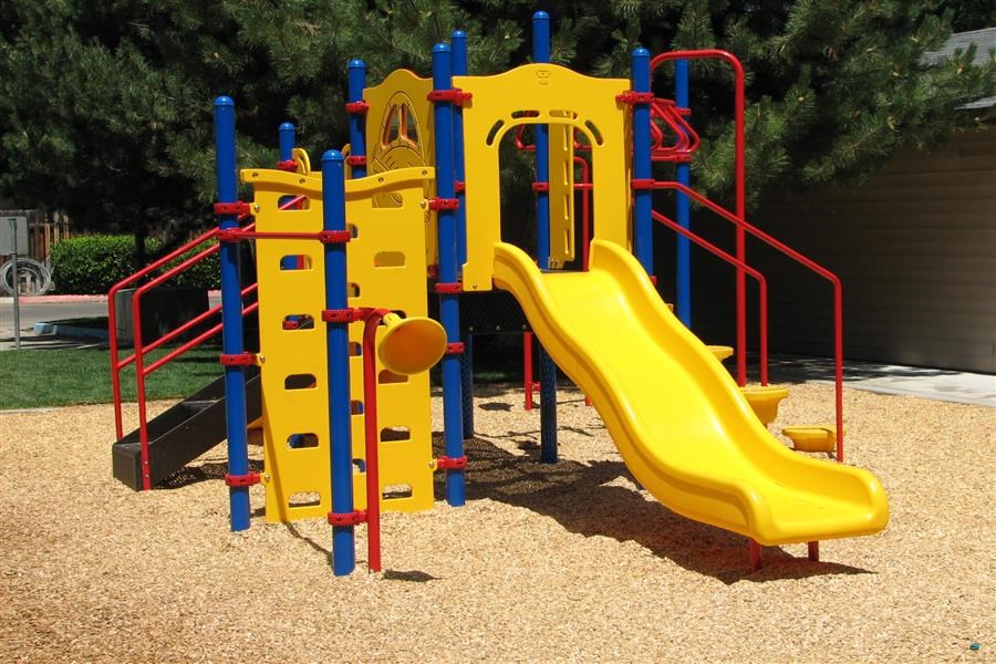 a blue and yellow slide on a playground