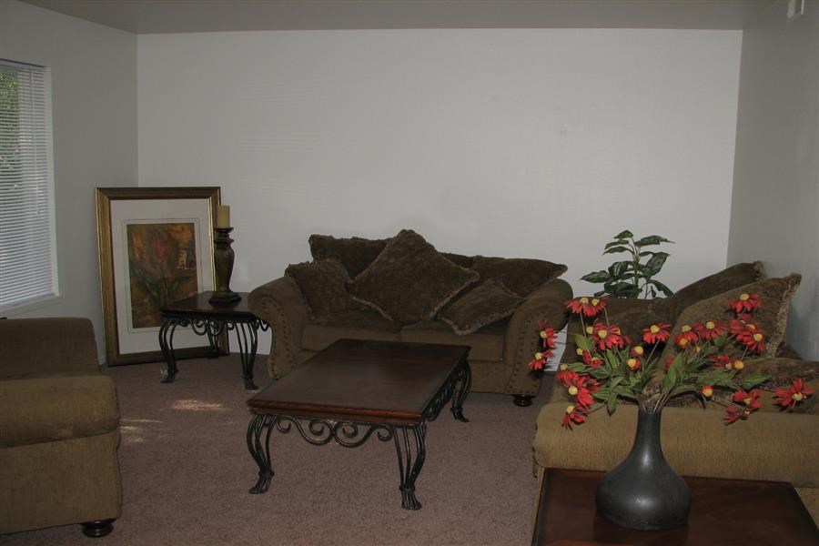 a living room with couches and a table with flowers