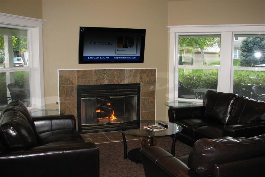 a living room with a fireplace and leather furniture