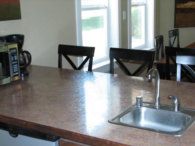 a kitchen counter with a sink and a microwave