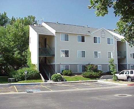 an apartment building with a car parked in a parking lot