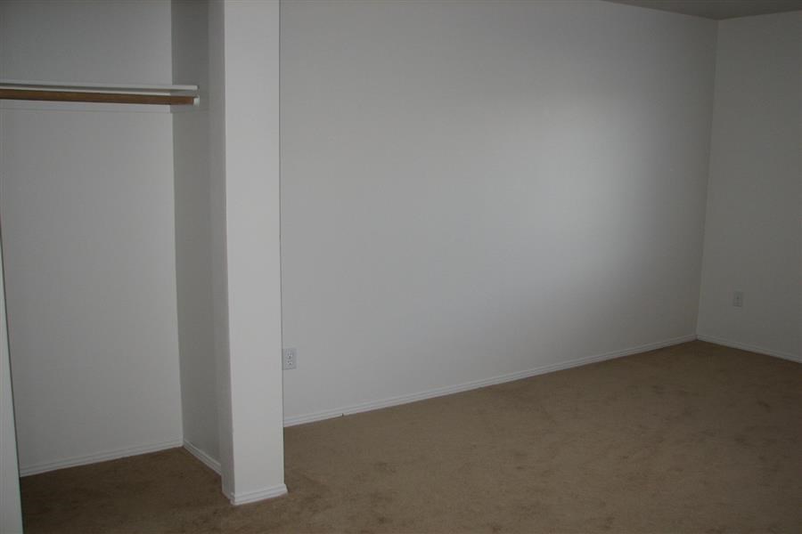 an empty room with a white wall and a closet