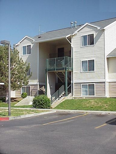 a white apartment building with stairs on a street