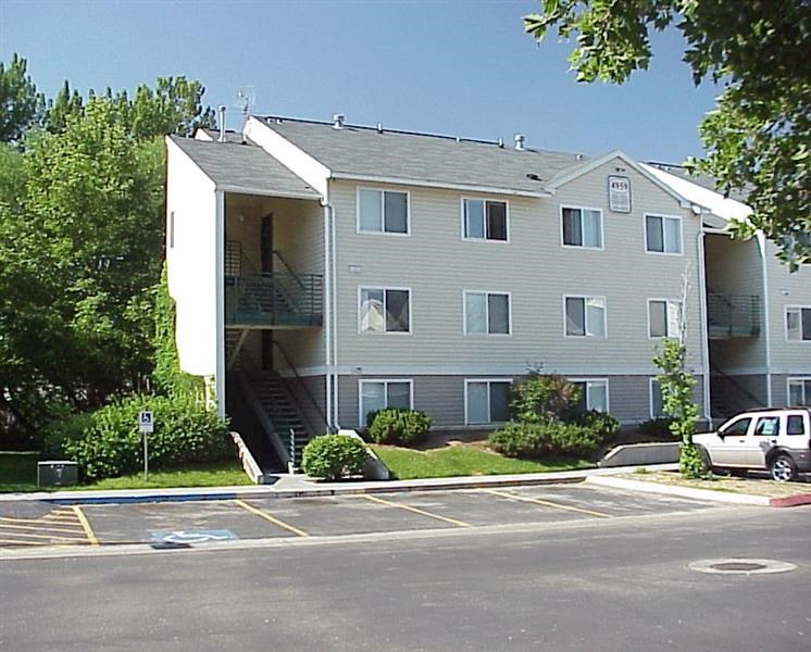 an apartment building with a car parked in a parking lot