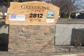 a stone sign for the greystone court