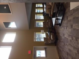 a room with a bunch of windows and a brick wall