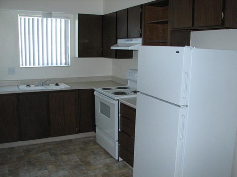 a kitchen with a white refrigerator and a sink