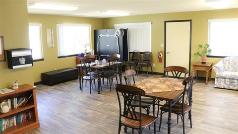 a living room with tables and chairs and a television