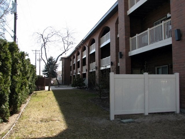 a white fence in front of an apartment building