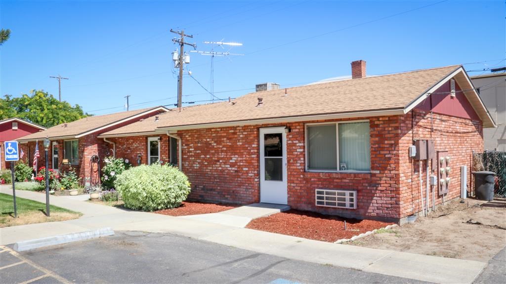 a small red brick house with a white door