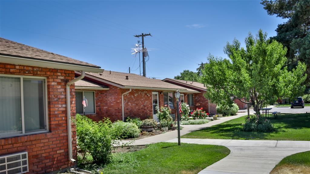 a brick house with a sidewalk in front of it