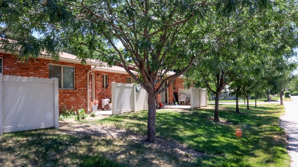 a red brick house with trees in front of it