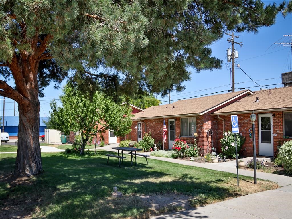 a small red brick building with a picnic table in front of it