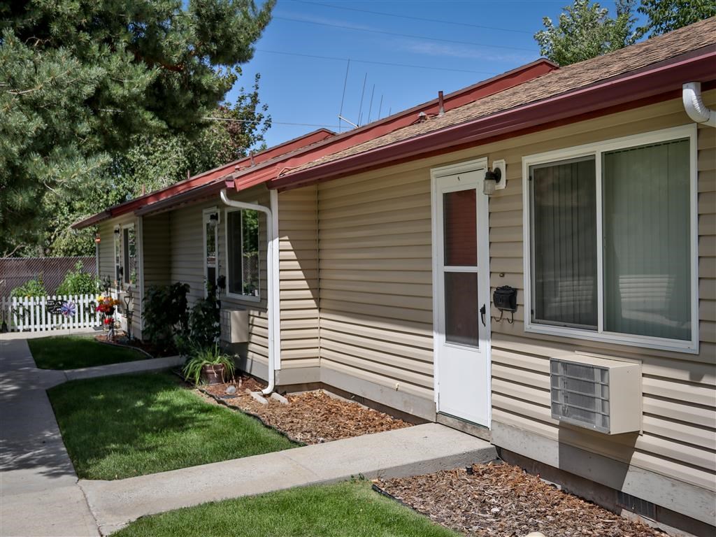 the front of a tan house with a white door