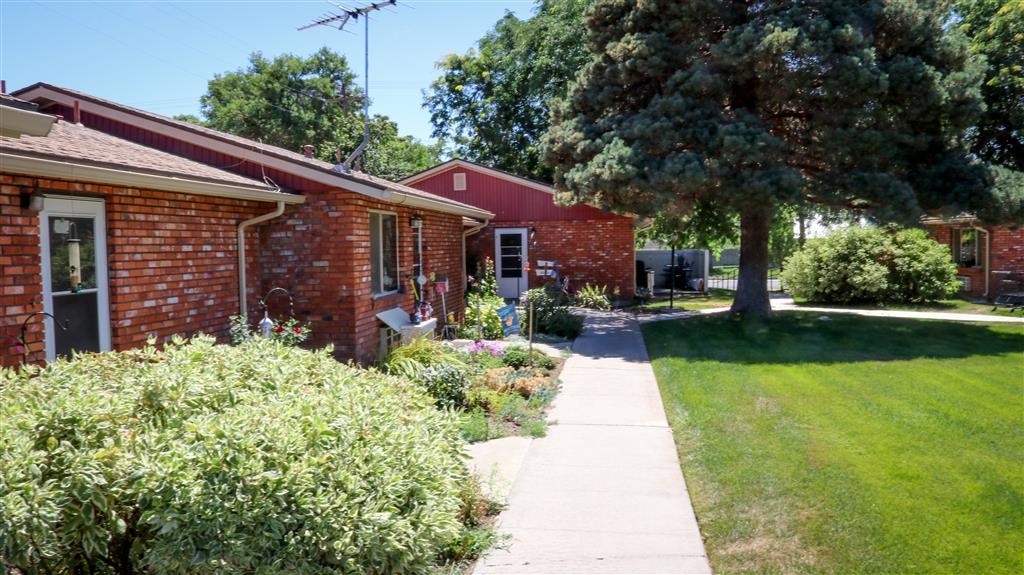 a sidewalk in front of a red brick house