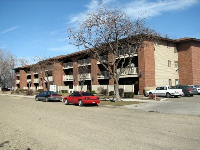 a large brick building with cars parked in front of it