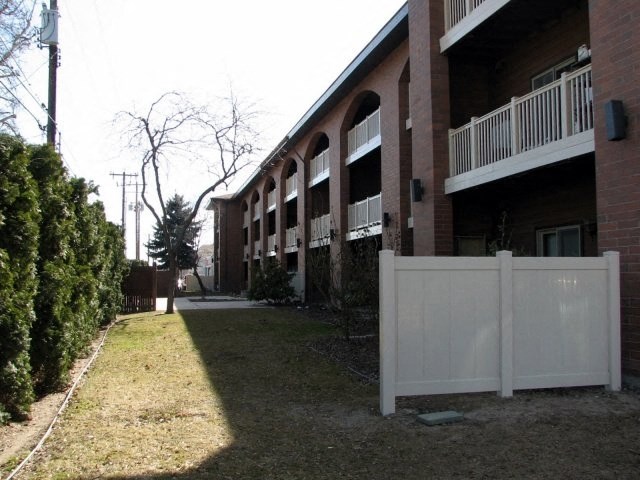 a white fence in front of an apartment building