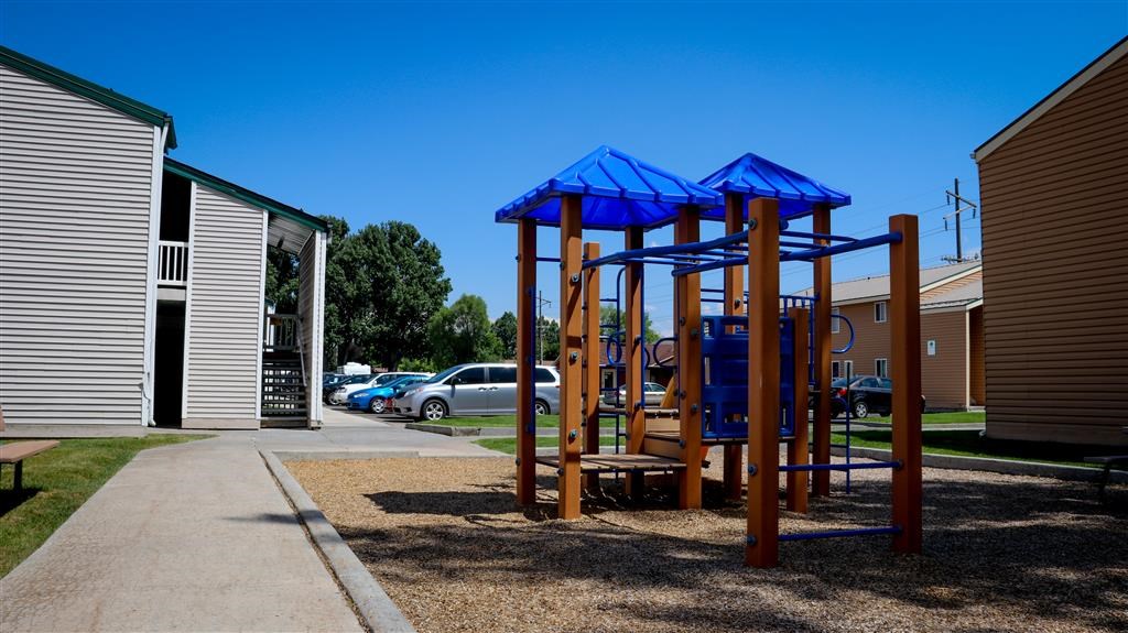 a playground with a swing set on a sidewalk