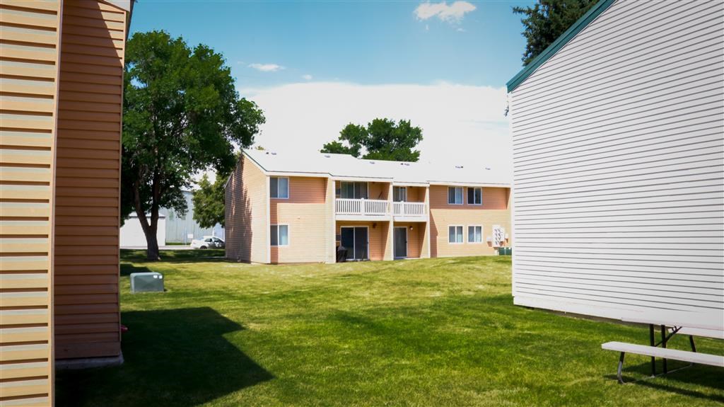 an apartment building with a yard and a picnic table