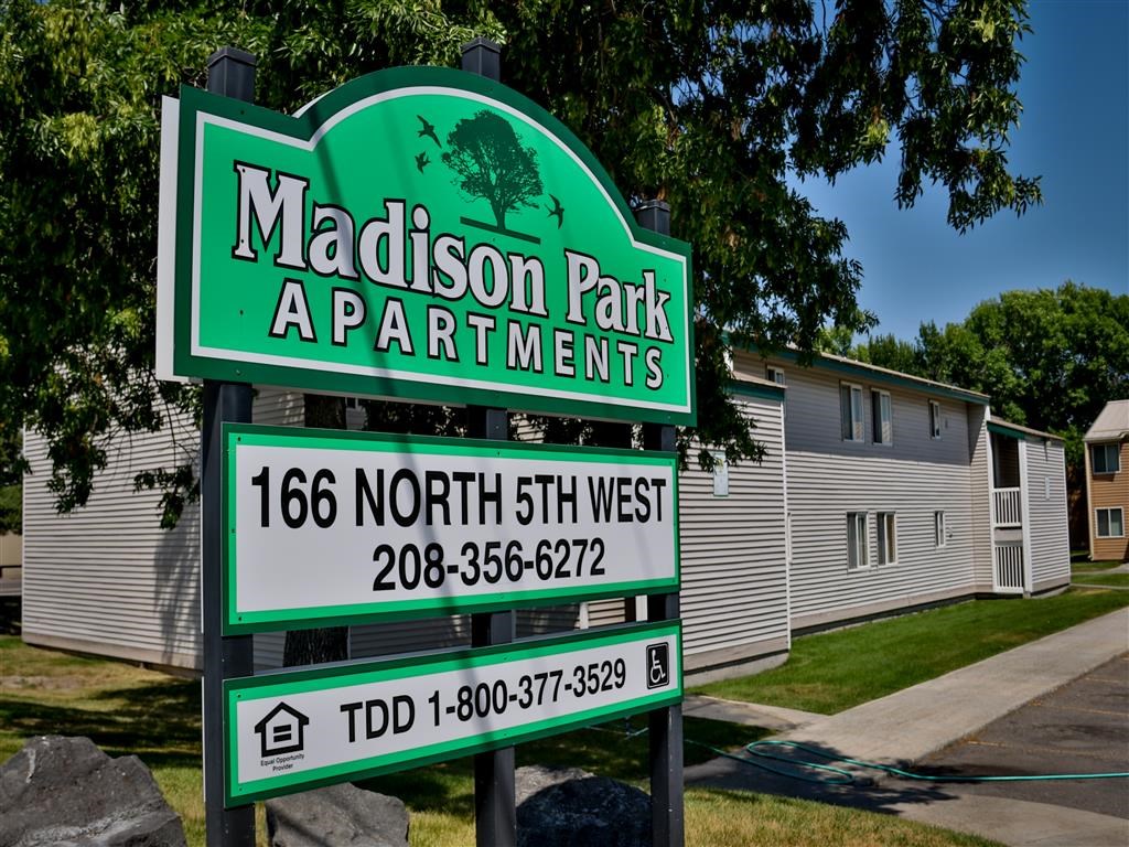 a sign for madison park apartments in front of a house