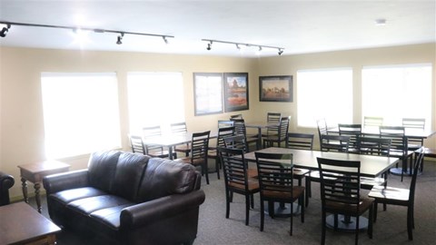 a living room with tables and chairs and a leather couch