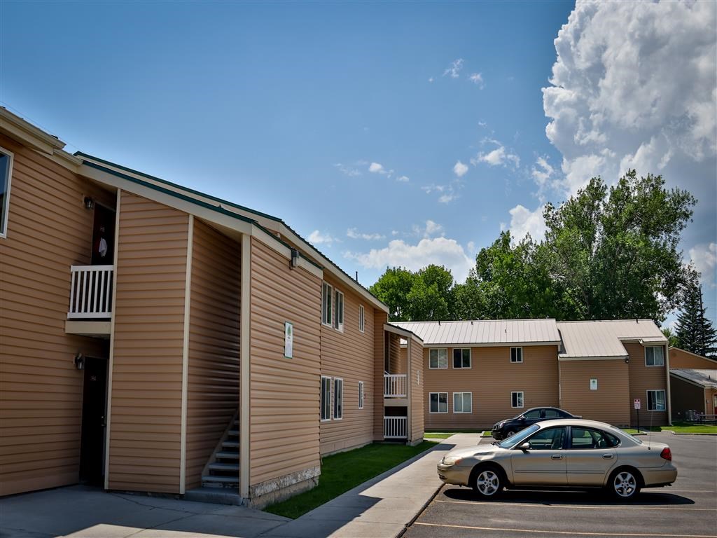 an apartment building with a car parked in a parking lot