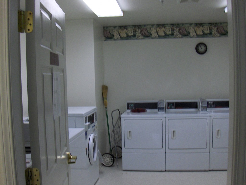 a laundry room with three washers and two dryers in it
