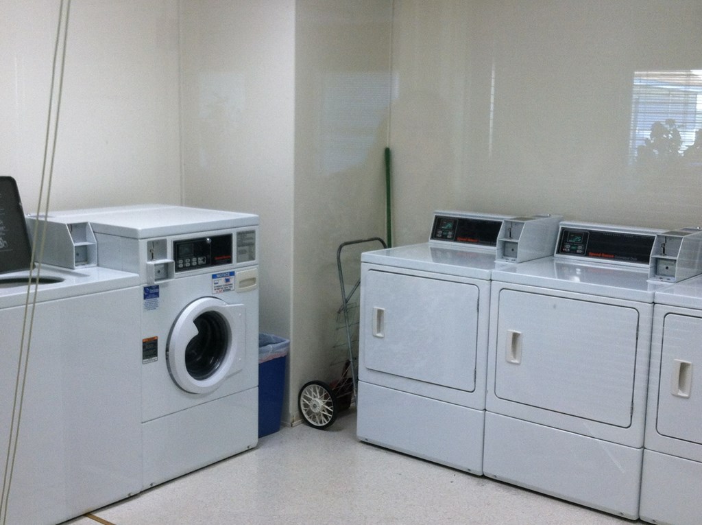 two washing machines and two dryers in a laundry room