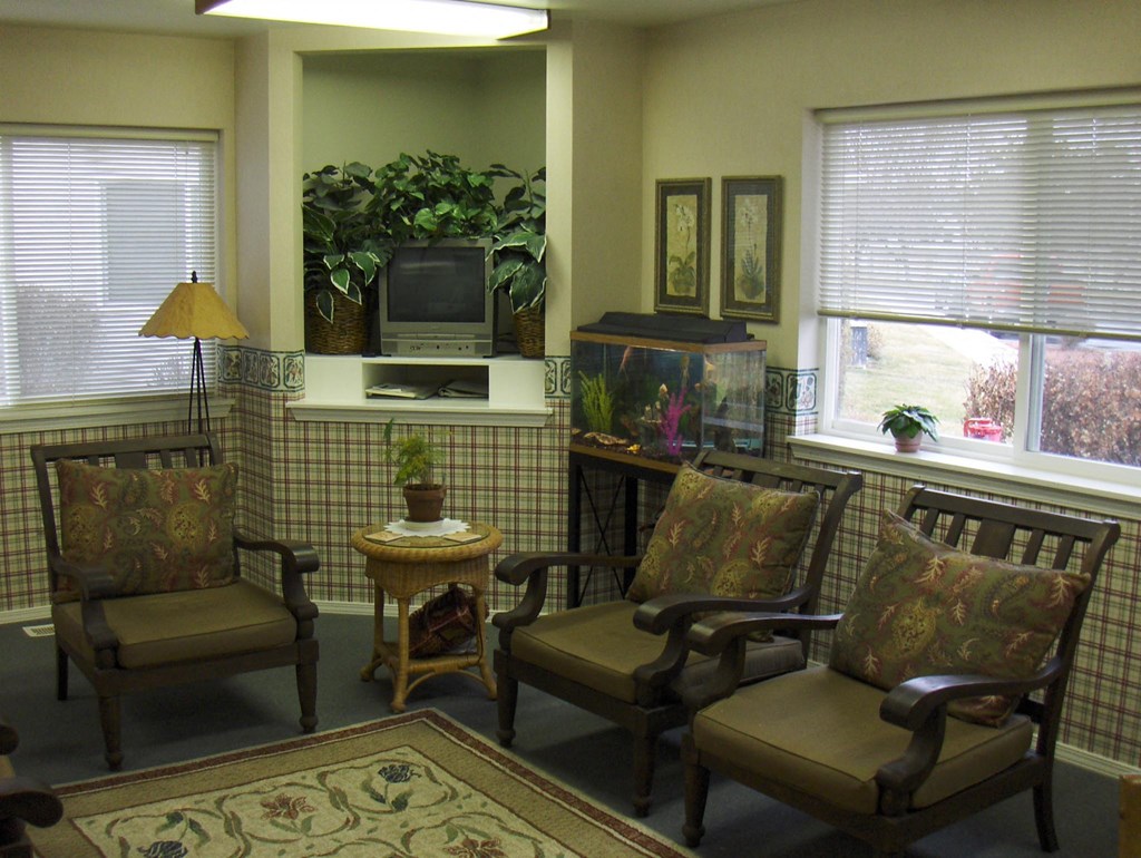 a living room with chairs and a television