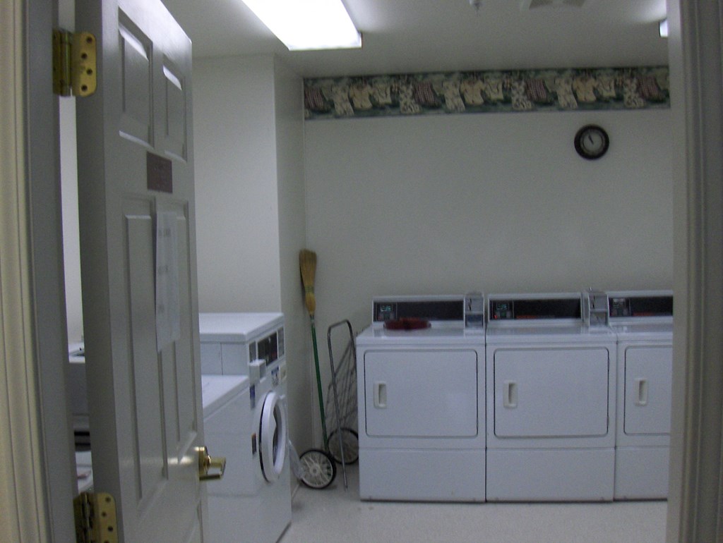 a laundry room with three washers and two dryers in it