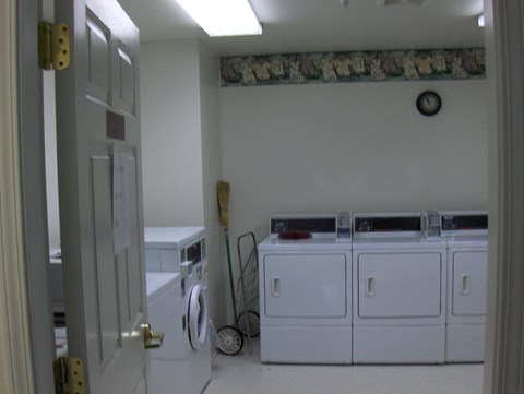 a laundry room with three washers and two dryers in it