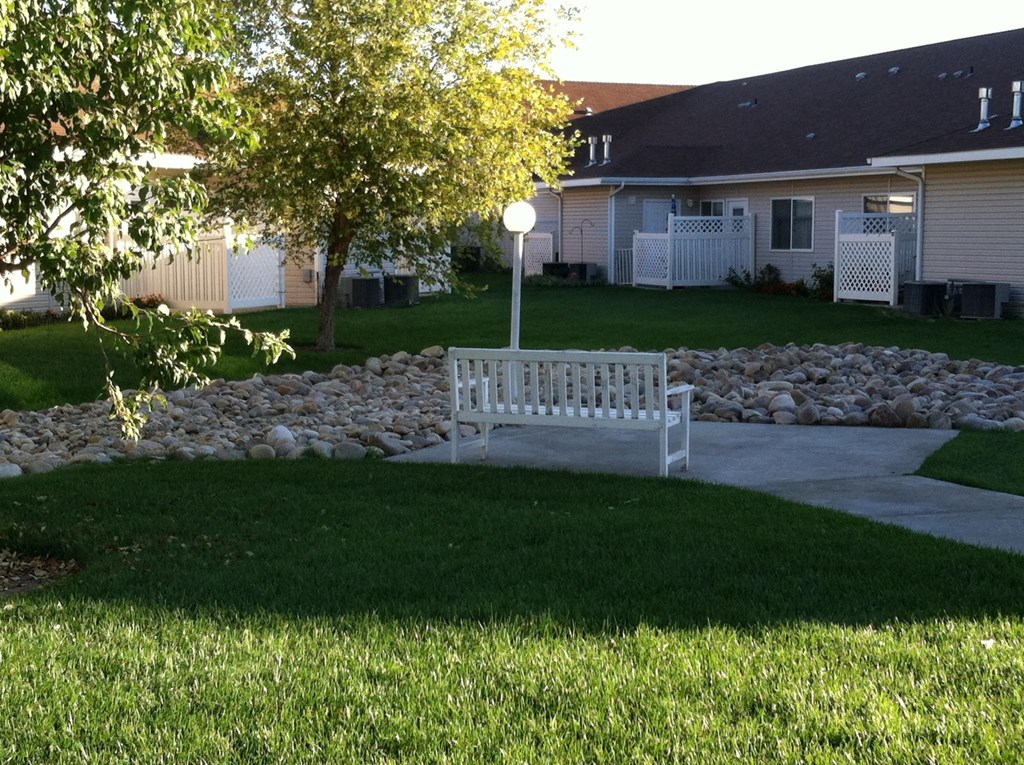 a park bench in the front yard of a house
