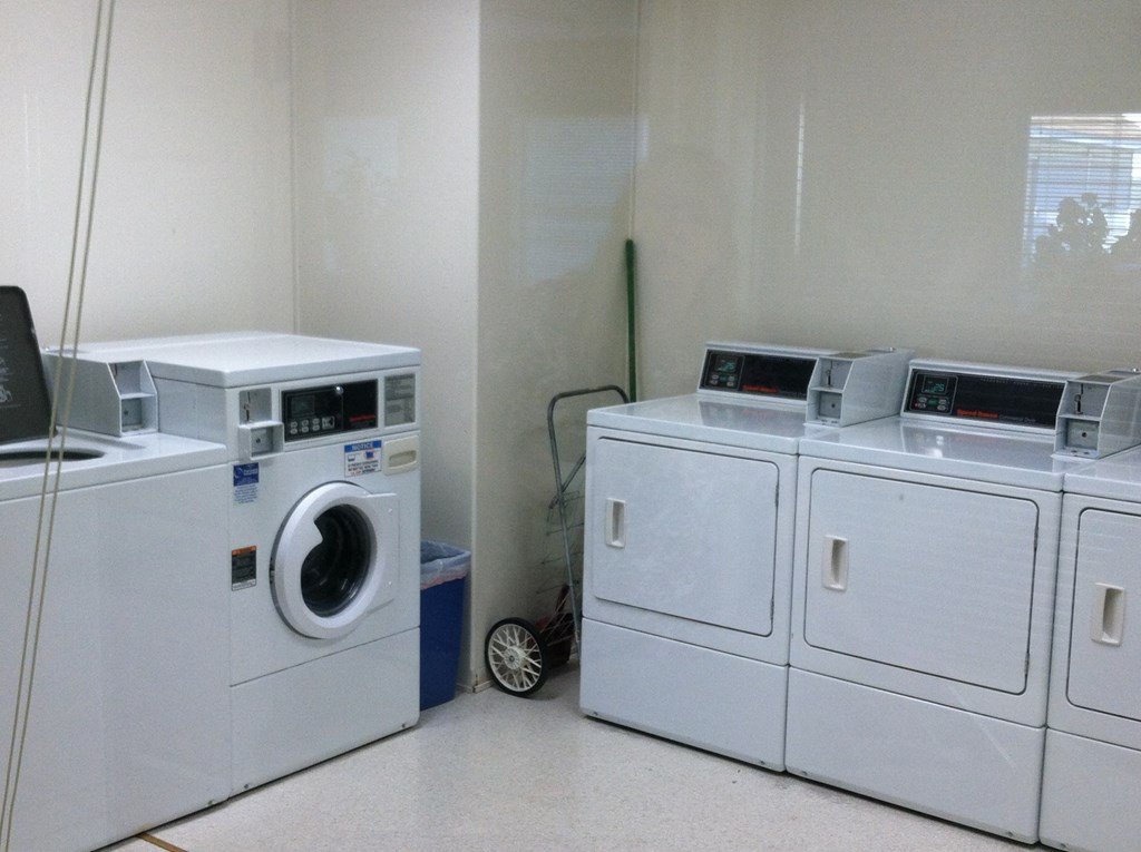 two washing machines and two dryers in a laundry room