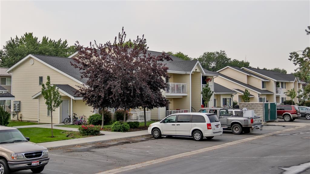 a row of houses with cars parked in front of them