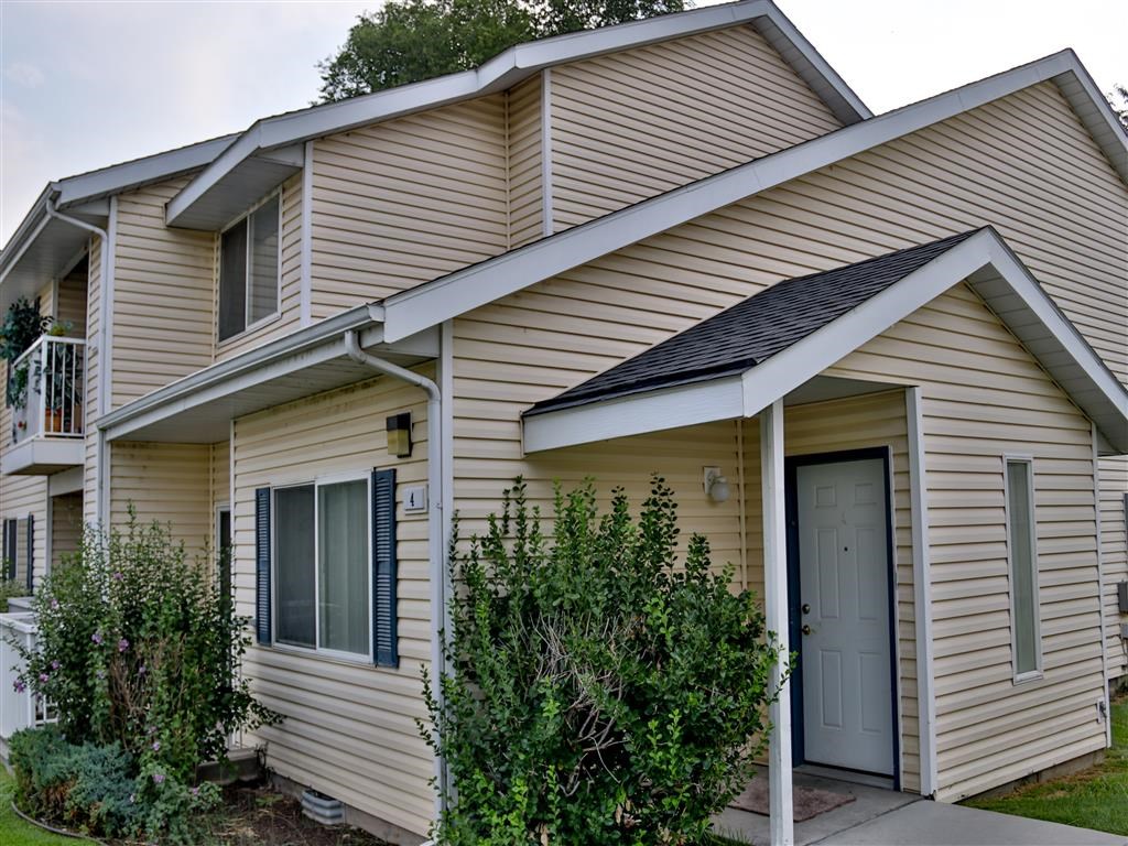 the front of a yellow house with a blue door