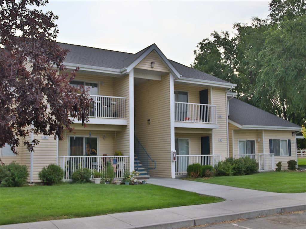 a yellow house with a porch and a yard