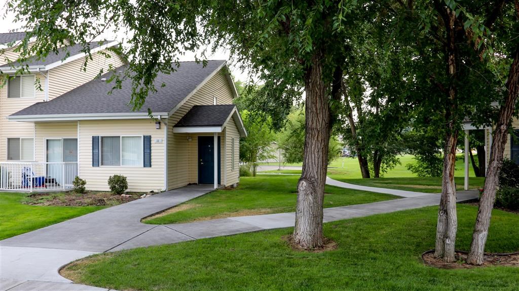 a white house with a sidewalk and trees