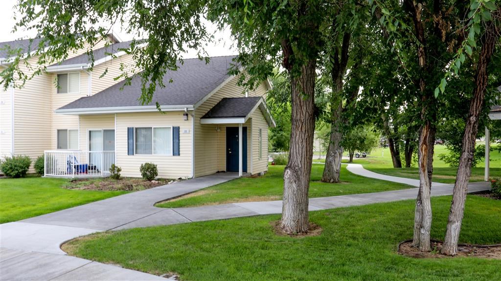 a white house with a sidewalk and trees
