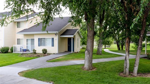 a white house with a sidewalk and trees