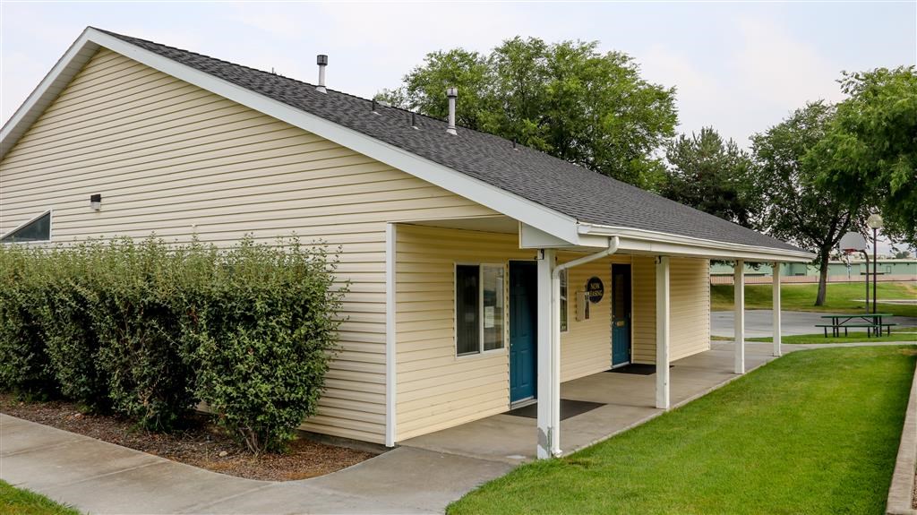 a small yellow house with a porch and a sidewalk