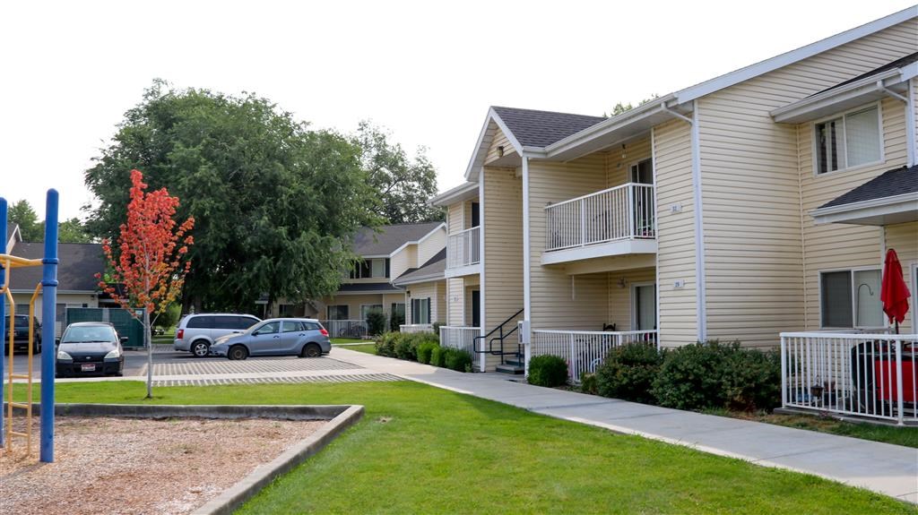 an apartment building with cars parked in front of it