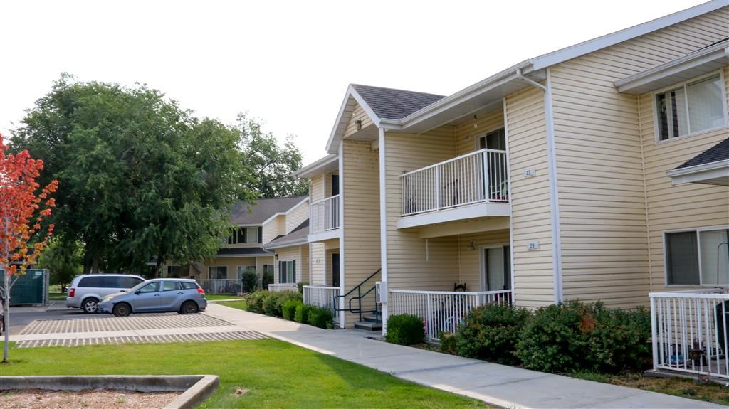 a row of houses with cars parked in front of them