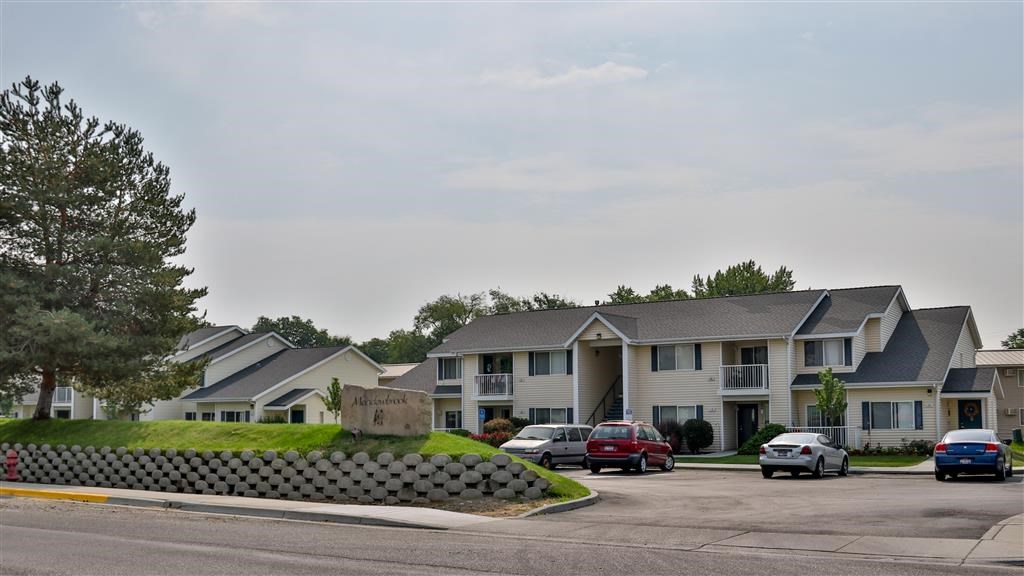 a row of houses with cars parked in a parking lot
