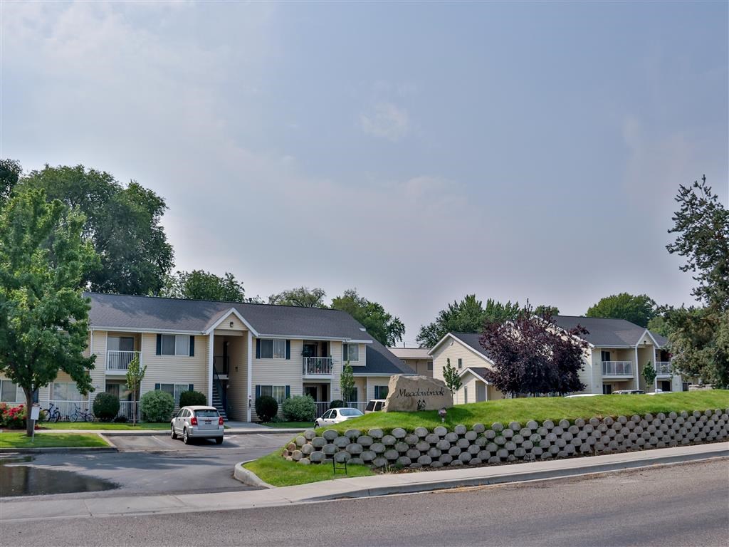 a row of houses with cars parked in front of them