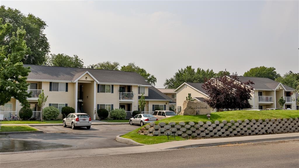 a row of houses with cars parked in front of them