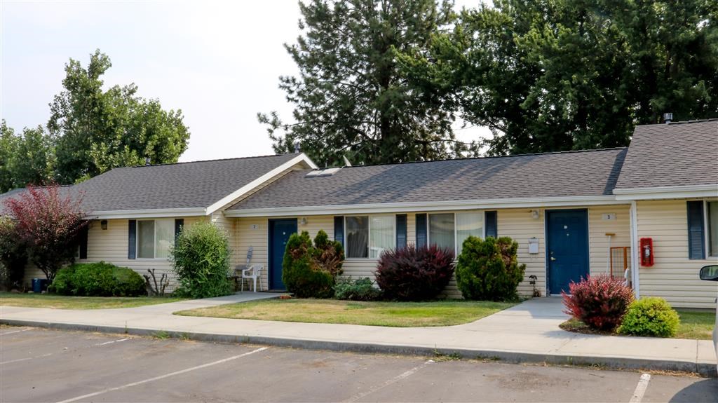 a white house with blue doors and a lawn