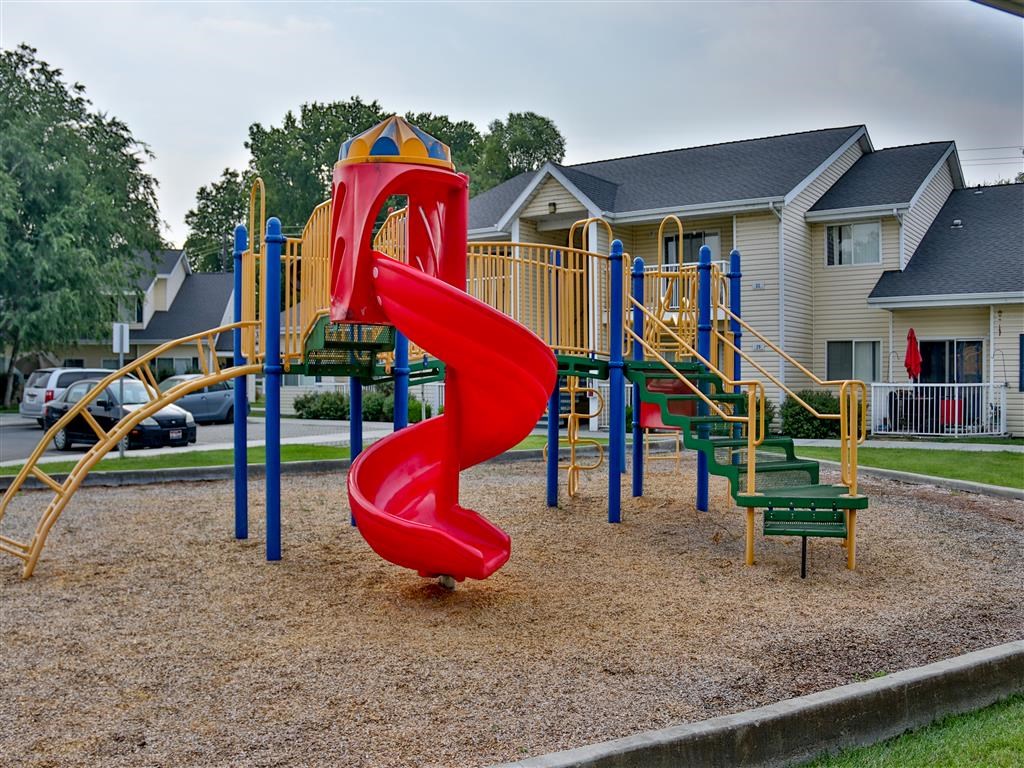 a playground with a red slide and a