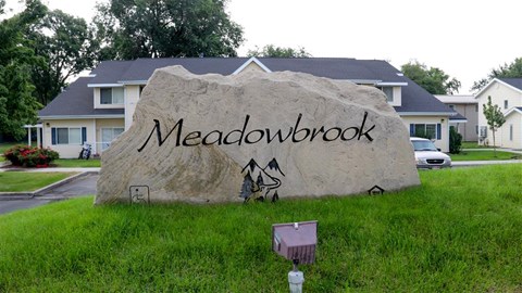 a large rock with the word on it in front of a house