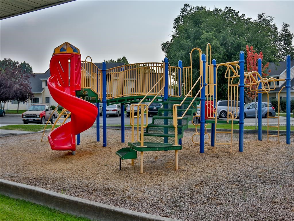 a playground at a park with a red slide